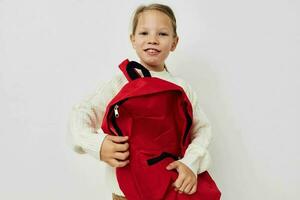 retrato do feliz sorridente criança menina escola vermelho mochila posando luz fundo foto