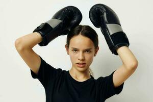 lindo menina dentro Preto Esportes uniforme boxe luvas posando estilo de vida inalterado foto