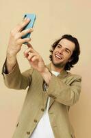 alegre homem dentro uma terno posando emoções olhando às a telefone isolado fundo foto