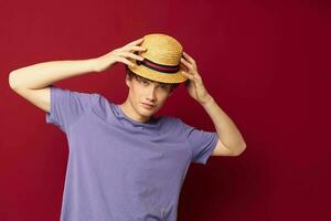 jovem cara moda posando mão gestos à moda chapéu vermelho fundo inalterado foto