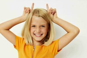 menina com loiro cabelo gesto com mãos posando fechar-se foto