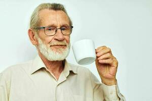 a idosos homem segurando uma caneca em uma branco fundo e sorridente foto