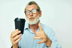 retrato do feliz Senior homem gestos com dele mãos uma vidro do beber isolado fundo foto