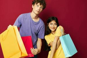 retrato do uma homem e uma mulher colorida bolsas compras Diversão isolado fundo inalterado foto