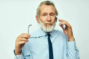 foto do aposentado velho homem dentro uma camisa com uma gravata com uma telefone tecnologia luz fundo