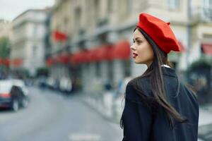 moda mulher retrato beleza em pé em a rua dentro frente do a cidade dentro à moda roupas com vermelho lábios e vermelho boina, viagem, cinematográfico cor, retro vintage estilo, urbano moda estilo de vida. foto