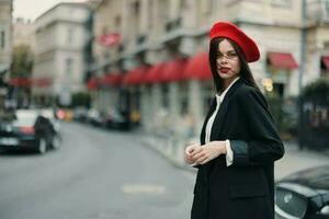 moda mulher retrato em pé em a rua dentro frente do a cidade dentro à moda roupas com vermelho lábios e vermelho boina, viagem, cinematográfico cor, retro vintage estilo, urbano moda estilo de vida. foto