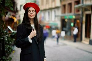 mulher moda modelo anda em em a rua dentro a cidade Centro entre a multidão dentro uma Jaqueta e vermelho boina e jeans, cinematográfico francês moda estilo roupas, viagem para Istambul foto