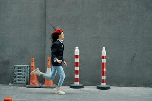 moda mulher corrida baixa a rua dentro frente do a cidade turista dentro à moda roupas com vermelho lábios e vermelho boina, viagem, cinematográfico cor, retro vintage estilo. foto