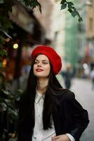 mulher sorrir moda modelo anda em em a rua dentro a cidade Centro entre a multidão dentro uma Jaqueta e vermelho boina e jeans, cinematográfico francês moda estilo roupas, viagem para Istambul Primavera foto
