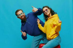 mulher e homem sorrir sentado em mala de viagem com vermelho mala de viagem sorriso, em azul fundo, embalagem para viagem, família período de férias viagem. foto