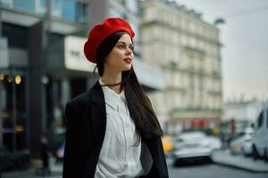 uma o negócio mulher anda em dentro a cidade contra a pano de fundo do escritório edifícios, à moda elegante roupas e inventar, Primavera andar, viagem. foto