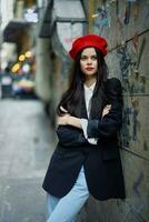 moda mulher retrato caminhando turista dentro à moda roupas com vermelho lábios caminhando baixa uma limitar cidade rua, viagem, cinematográfico cor, retro vintage estilo, dramático contra uma parede com grafite. foto