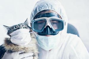 homem de terno e gato com máscara médica foto