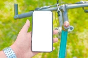 homem treina de bicicleta com smartphone foto