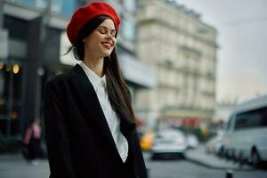 uma sorrir mulher com o negócio dentes anda em dentro a cidade contra a pano de fundo do escritório edifícios, à moda elegante roupas e inventar, Primavera andar, viagem. foto