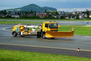 aeroporto pista limpeza. aeródromo concreto e asfalto superfície limpador. limpa-neve. neve e sujeira remoção trator veículo. foto