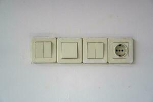 1 tomada e três trocar. elétrico tomada e luminária interruptor botão em a muro. foto