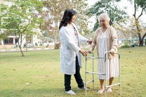 médico ajuda e cuidados idosos idosas asiáticas usam andador com forte saúde ao caminhar no parque foto