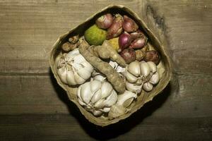 a legumes ingredientes para cozinhando em a tecido bambu. ervas fotografia. adequado para cozinha fundo imagem foto