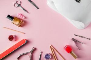 um conjunto de ferramentas para manicure e tratamento de unhas no local de trabalho com fundo rosa em um salão de beleza foto