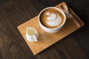 latte art quente na mesa de madeira foto