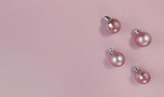 bolas de Natal rosa em um papel pastel. lay flat simples com espaço de cópia.