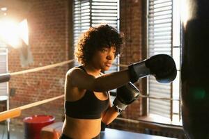 mulheres auto defesa menina poder. africano americano mulher lutador Treinamento socos em boxe anel. saudável Forte menina soco boxe bolsa. Treinamento dia dentro boxe academia. força em forma corpo exercite-se treinamento. foto