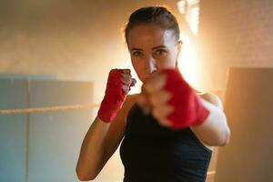 mulheres auto defesa menina poder. Forte mulher lutador soco com vermelho boxe envoltórios Esportes protetora bandagens. menina soco Treinamento socos olhando concentrado direto. em forma corpo dar certo. foto