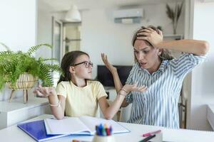 mãe tornando-se frustrado com filha enquanto fazendo trabalho de casa. mãe faz a melhor professor sempre. mãe repreensões uma criança para pobre escolaridade e dever de casa às casa foto