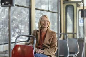 1 jovem mulher sorridente dentro uma ônibus enquanto olhando através a janela lindo jovem mulher levando ônibus para trabalhar. passageiro dentro a ônibus ou trem, tecnologia estilo de vida, transporte e viajando conceito. foto