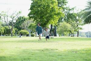 feliz sudeste ásia meninas jogando ao ar livre dentro a Primavera parque. ásia crianças jogando dentro a jardim verão período de férias. foto