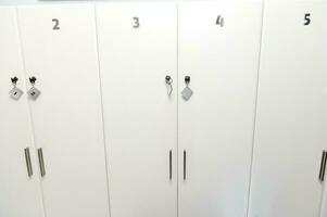 branco numerado armários dentro a corredor do a esperando quarto do uma médico clínica ou spa salão dentro minimalista à moda Projeto foto