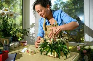 floral artista cria flor arranjos, trabalhando dentro floricultura estúdio. pequeno negócios. criativo passatempo. pessoas foto