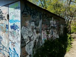 abandonado velho garagem delineado de do autor grafite e cheio com vegetação e musgo. Ucrânia, zaporozhye, pode 2023 foto