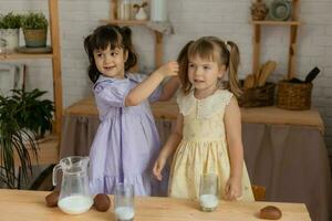 pequeno feliz meninas idiota por aí dentro a Primavera e cozinhar dentro a cozinha foto