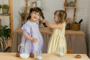 pequeno feliz meninas idiota por aí dentro a Primavera e cozinhar dentro a cozinha foto