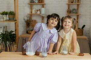 pequeno feliz meninas idiota por aí dentro a Primavera e cozinhar dentro a cozinha foto