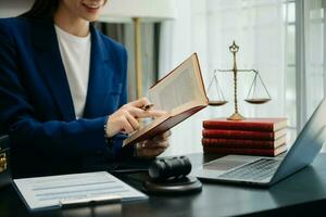 mulher advogado lendo legal livro com martelo em mesa dentro escritório. justiça e lei ,advogado conceito. foto