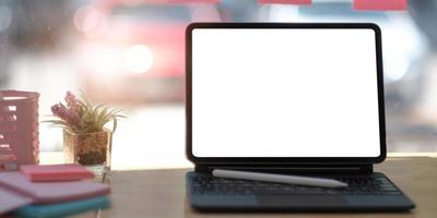 foto recortada de um espaço de trabalho confortável com um laptop de tela em branco e suprimentos de escritório na mesa de madeira