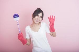 linda dona de casa asiática sorrindo em fundo rosa foto