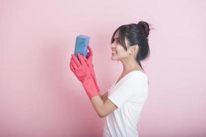 linda dona de casa asiática sorrindo em fundo rosa foto