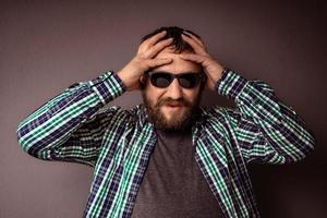 hipster bonito barbudo homem com óculos escuros e camisa foto