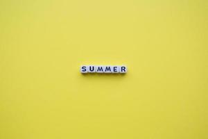 cubos de palavra de verão, sobre um fundo amarelo. foto