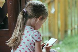 jovem pré-escolar usando smartphones, crianças usando tecnologia digital foto