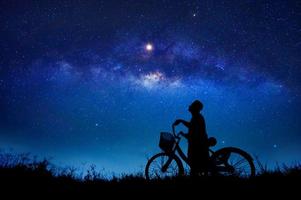 a pessoa está pedalando no meio da galáxia de estrelas foto