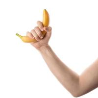 mão masculina segurando banana. isolado no fundo branco.