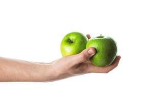 homem segurando duas maçãs verdes na mão. isolado no fundo branco. foto
