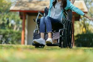 jovem ásia mulher dentro cadeira de rodas com positivo pensamento. foto