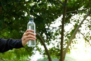 desportista bebendo alguns água a partir de uma garrafa depois de treinamento. foto